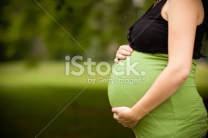 stock-photo-19606702-young-caucasian-woman-holding-her-pregnant-belly-with-copy-space